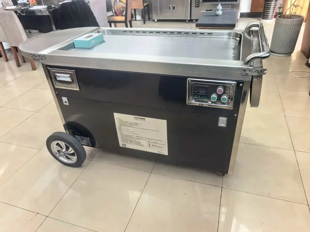 Black cabinet portable teppanyaki with digital control panel.