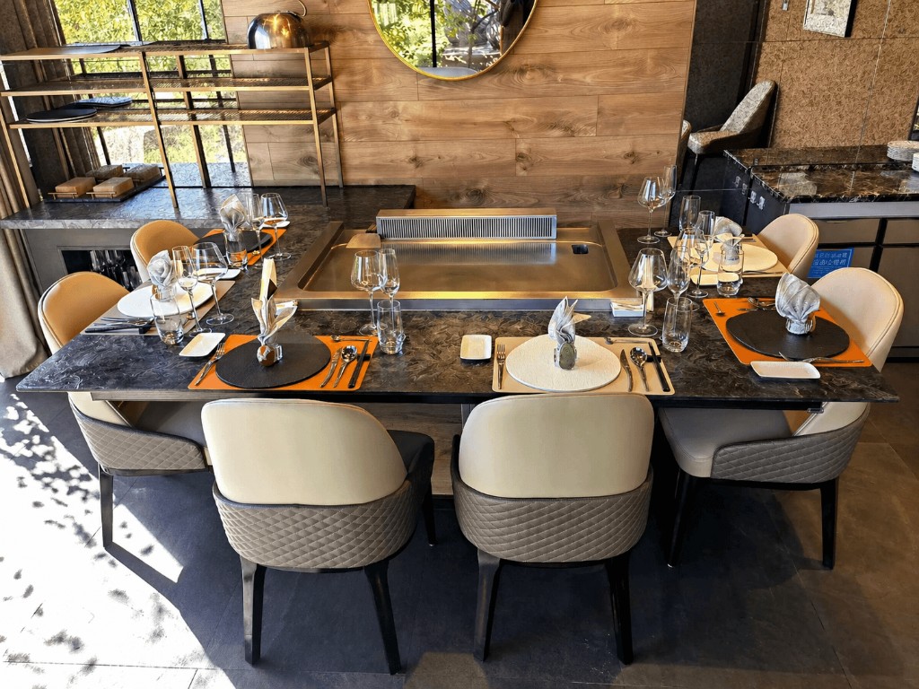 Private teppanyaki dining table with built-in grill, marble top, and six place settings