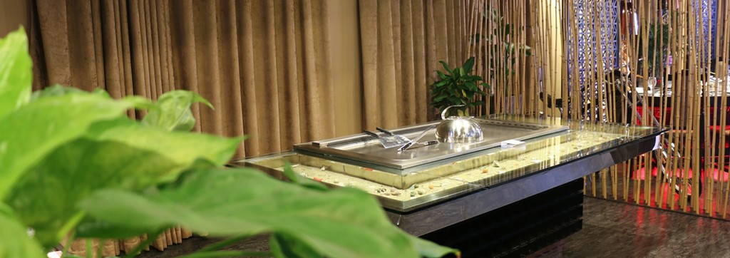 Luxury Saudi restaurant interior with teppanyaki grill and tropical greenery