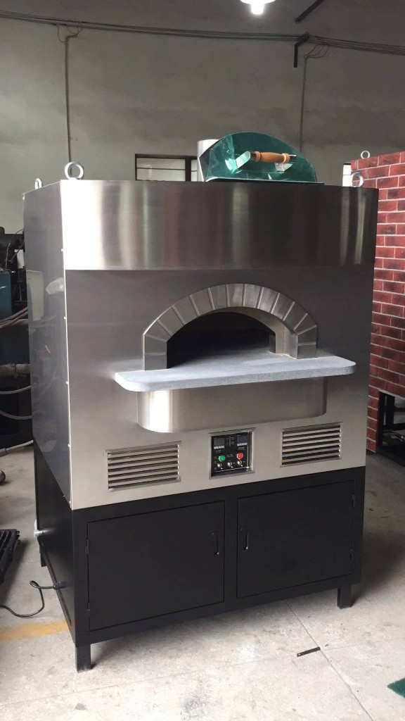Freestanding stainless steel dome outdoor pizza oven with arched mouth, stone landing, dual digital controls, side vents, and black storage cabinet base