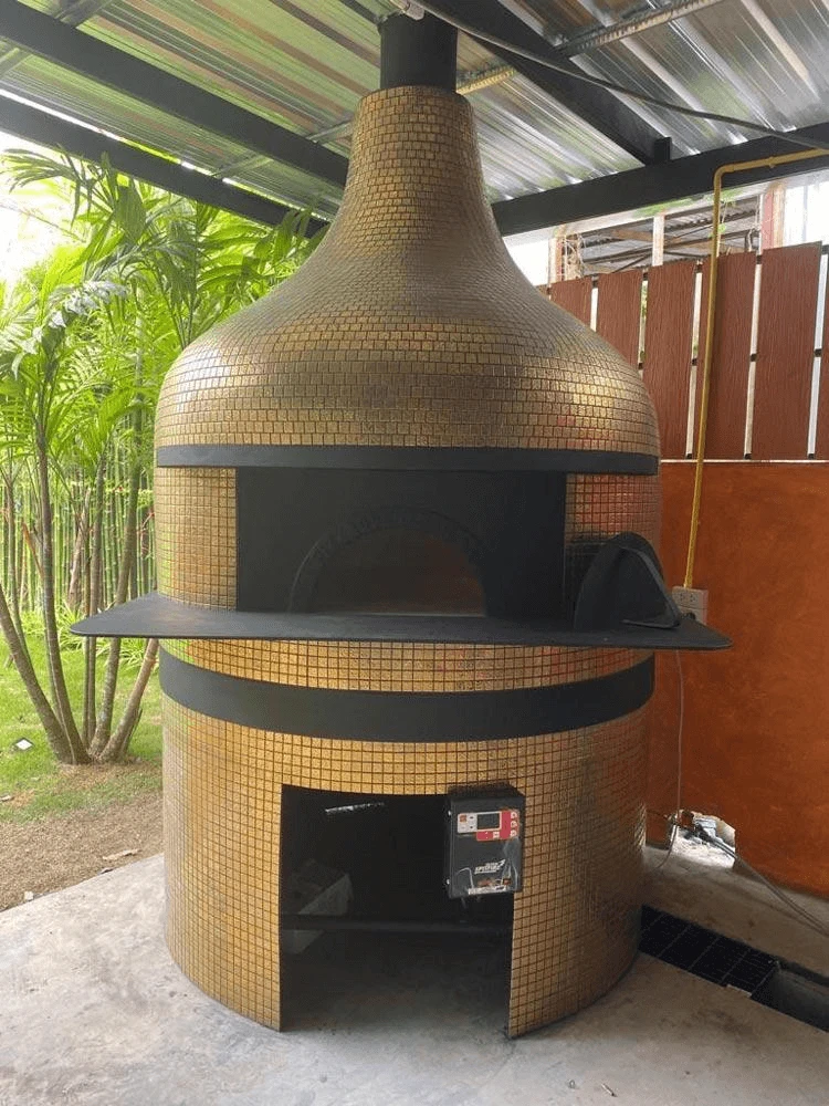 Gold mosaic commercial pizza oven in an outdoor patio kitchen setting