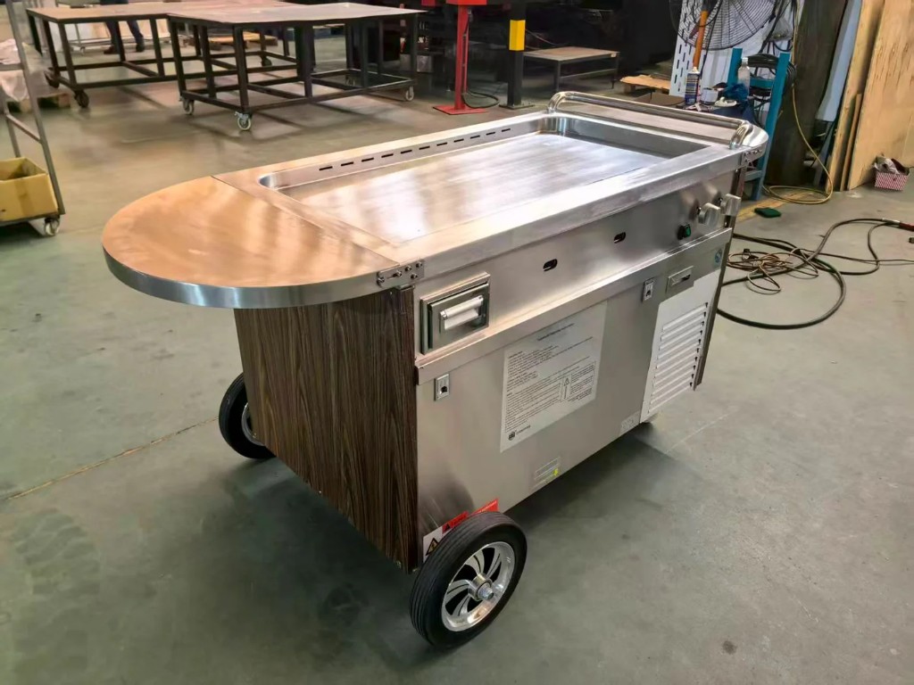 Stainless portable cart with wood accent and large wheels.
