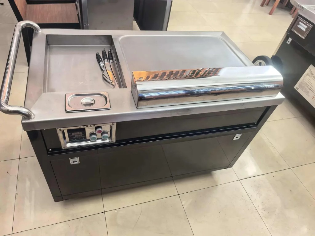 Electric teppanyaki griddle with digital controls and integrated prep details.