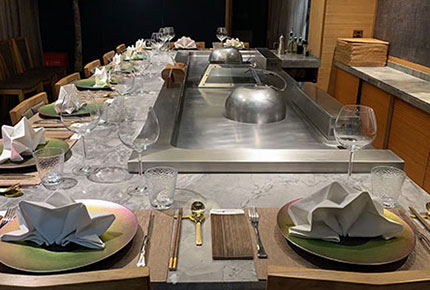 Formal place settings on a marble teppanyaki counter