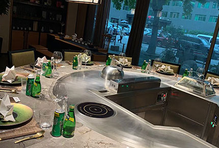 Curved teppanyaki dining counter and seating by a window