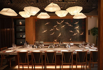 Private teppanyaki room with built-in grill counter and crane wall art
