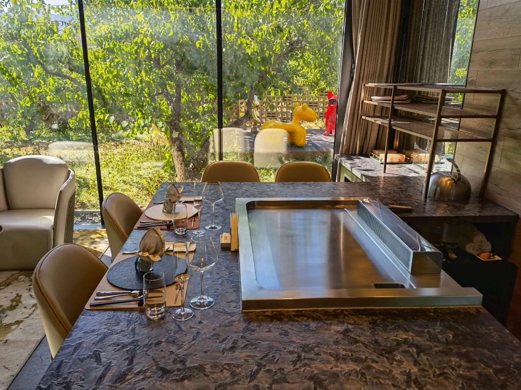Residential electric and gas teppanyaki grill table in a home dining room with built-in cooktop and seating